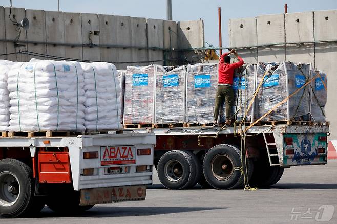 이스라엘 남부 케렘 샬롬 검문소에서 한 트럭 기사가 가자지구로 향하는 구호품을 밧줄로 고정하고 있다. 2024.03.14/ ⓒ 로이터=뉴스1 ⓒ News1 권진영 기자