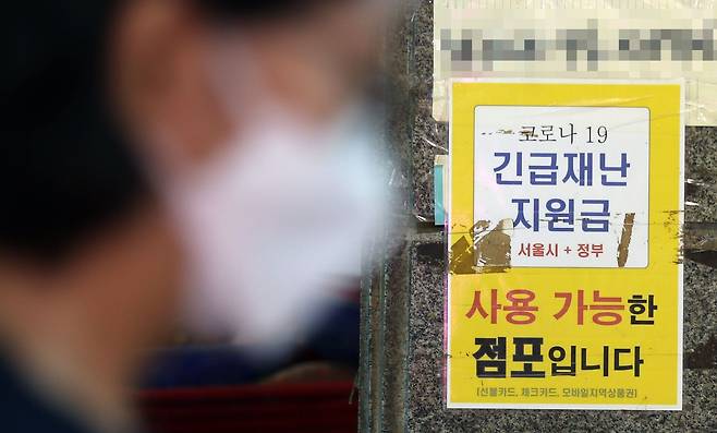 지난 2021년 서울의 한 가게에 붙은 코로나 상생 국민지원금(재난지원금) 사용 안내 문구. 당시 정부는 전 국민의 약 88%가 1인당 25만원씩 받는다고 발표했다. / 연합뉴스