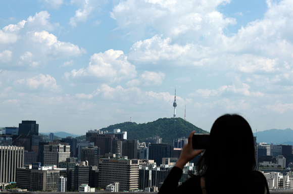 8일 서울 종로구 무무대전망대를 찾은 한 시민이 휴대전화로 풍경을 촬영하고 있다. [사진=뉴시스]