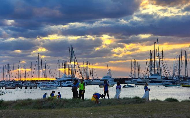 호주 멜버른 근교 샌드리엄 해변 해질녘, 아이들이 해변 환경을 정화하는 비치코밍을 하고 있다.