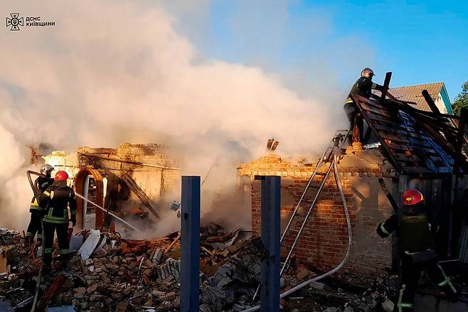 8일(현지시간) 러시아의 공습을 받은 우크라이나 키이우 지역에서 구조대원들이 진화작업을 하고 있다. [AFP]