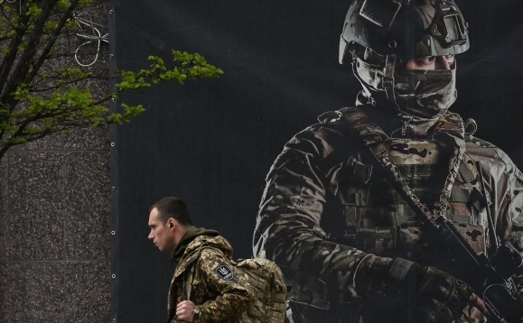 지난달 우크라이나의 한 군인이 입대 포스터 앞을 지나가고 있다. AFP 연합뉴스