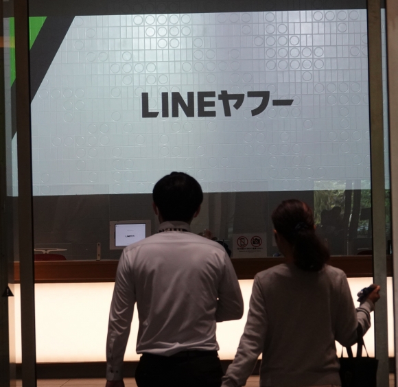 ‘라인야후’ 일본 본사에 오가는 사람들 - 9일 오후 라인야후가 입주해 있는 일본 도쿄 지요다구의 도쿄가든테라스기오이타워에 사람들이 들어가고 있다. 걸어가는 사람 앞으로 ‘라인야후’라고 적혀 있다. 도쿄 연합뉴스