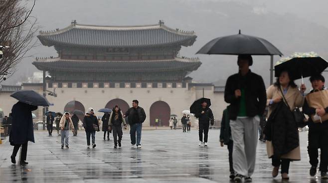 서울 종로구 광화문광장에서 시민들이 우산을 쓰고 이동하고 있다. 2024.02.18. 뉴시스