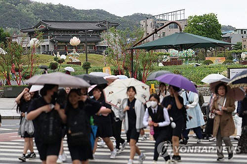 서울 전역에 비가 내린 7일 오후 서울 종로구 송현동공원 인근에서 시민들이 우산을 쓰고 이동하고 있다. [연합뉴스]