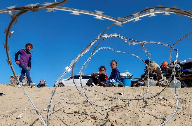 팔레스타인 주민들이 9일(현지시간) 가자지구 남부에서 자신의 소지품 옆에 앉아 있다. 로이터연합뉴스
