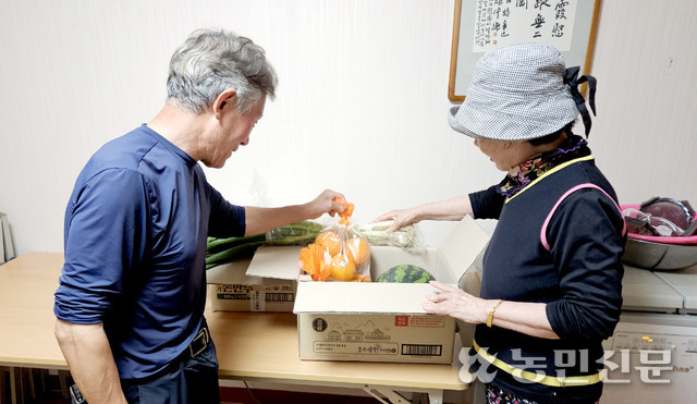 김재길 청평2리 이장(왼쪽)이 왕복 2시간 거리를 달려 사온 식재료를 부녀회장에게 보여주고 있다.