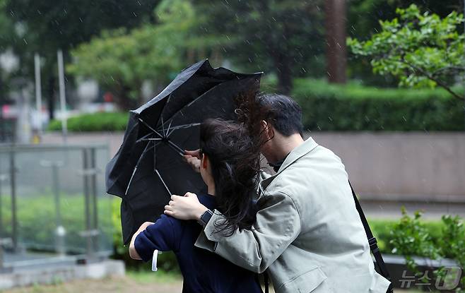 전국에 강풍을 동반한 비가 예고된 11일 오후 서울 종로구 도심을 지나는 한 시민들이 강한 바람에 위태로운 모양의 우산에 의지한 채 발걸음을 재촉하고 있다.  /뉴스1
