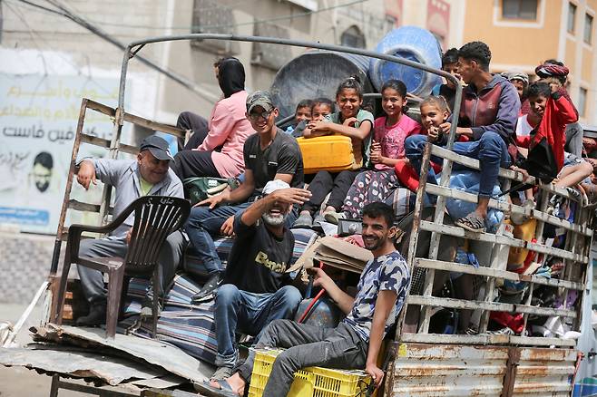 11일 가자지구 남부 라파 지역에서 이스라엘과 하마스의 충돌이 계속되고 있는 가운데 팔레스타인인들이 소지품을 실은 차량 뒤쪽에 앉아 대피 준비를 하고 있다. /로이터 연합뉴스