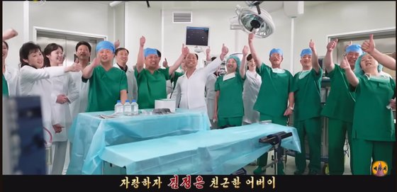 북한이 최근 공개한 선전 가요 '친근한 어버이'의 한 장면. 수술실의 의사들이 김정은을 외치며 환호하고 있다. 유튜브 '메아리' 캡처.