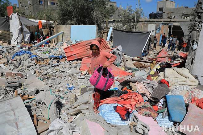 [라파=신화/뉴시스]지난 7일(현지시각) 가자지구 남부 라파에서 한 소녀가 이스라엘의 공습으로 파괴된 건물 잔해 속에서 가재도구를 찾아 모으고 있다. 팔레스타인 보건부는 이스라엘의 라파 공습으로 최소 20명의 팔레스타인인이 숨졌다고 밝혔다. 미 정부가 10일 미국이 지원한 무기를 사용한 이스라엘의 가자 공격이 국제 인도주의법을 위반했을 것이라는 내용의 보고서를 의회에 보냈다. 2024.05.11.