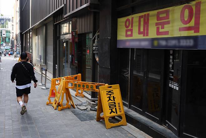 A passerby walks in front of an empty store with a "for rent" sign in Seoul, April 28. (Yonhap)