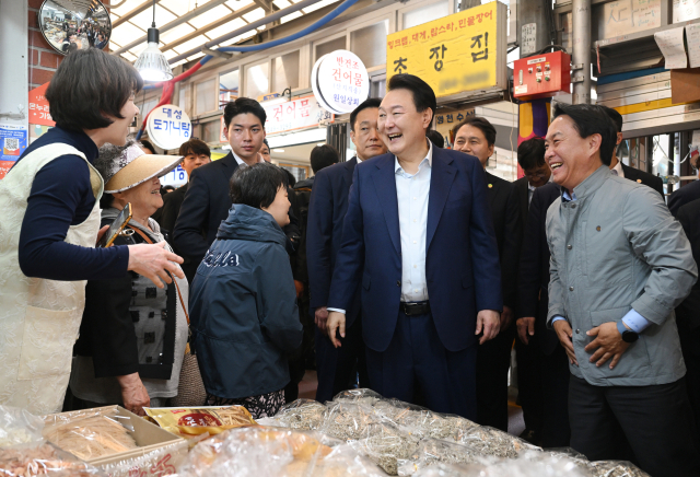 ▲윤석열 대통령이 10일 오후 서울 서대문구 영천시장을 찾아 한 점포에서 상인과 인사하고 있다. ⓒ연합뉴스