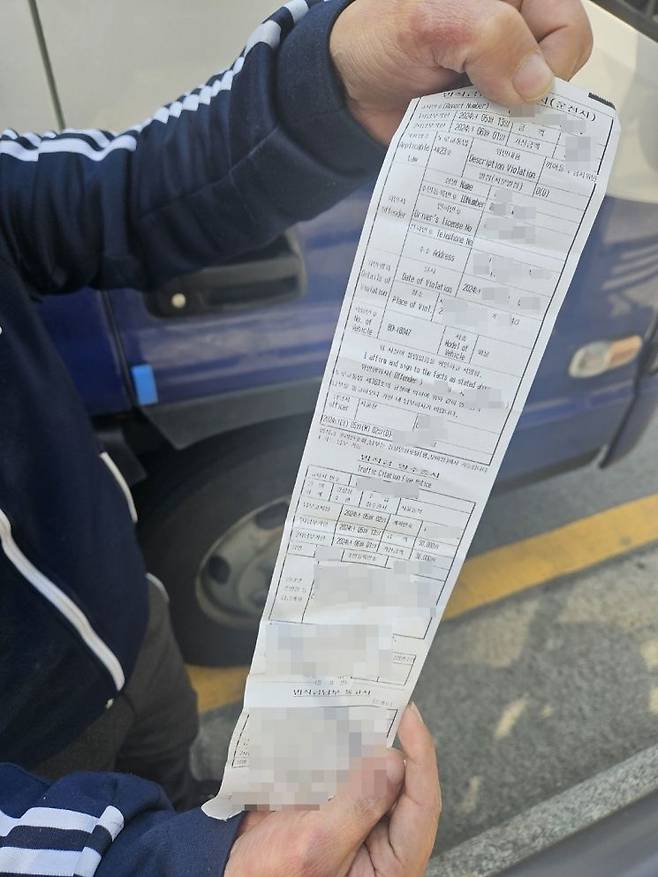 시위 트럭 운전기사 A씨가 트럭에 부과된 범칙금 고지서를 들어보이고 있다. [사진=이지은]