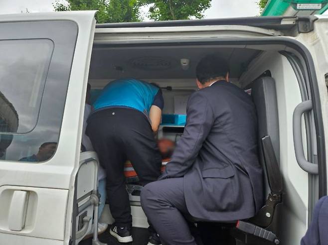 홍태용 김해시장(오른쪽)이 병원 차량에 올라 쓰러진 시민에 대한 활력 징후(바이탈)를 살피며 당부를 전하고 있다. [사진제공=김해시청]