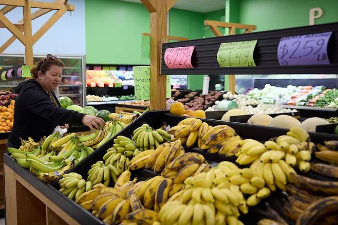 미국 로스앤젤레스의 식료품 가게에서 한 시민이 과일을 고르고 있다. 물가상승과 고금리로 미국 저소득층의 생활고도 심해지고 있다. EPA 연합뉴스