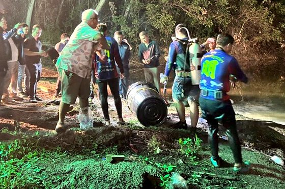 Thai police and divers on Saturday retrieve the body of a Korean tourist suspected to have been hidden in a black plastic barrel that had been submerged in a reservoir in Pattaya, Thailand, in a screen capture from Thai news media. [JOONGANG ILBO]