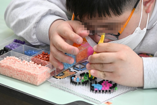한 발달장애 청소년이 지난 22일 서울 영등포구 문래청소년센터에서 집게를 들고 공예품을 만드는 데 집중하고 있다. 권현구 기자