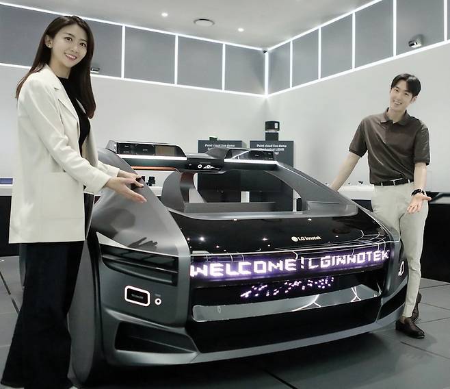 LG이노텍 직원들이 미래차 목업(Mock-up)에 장착된 차량 조명 모듈 ‘넥슬라이드’를 선보이고 있다. [사진출처 = LG이노텍]