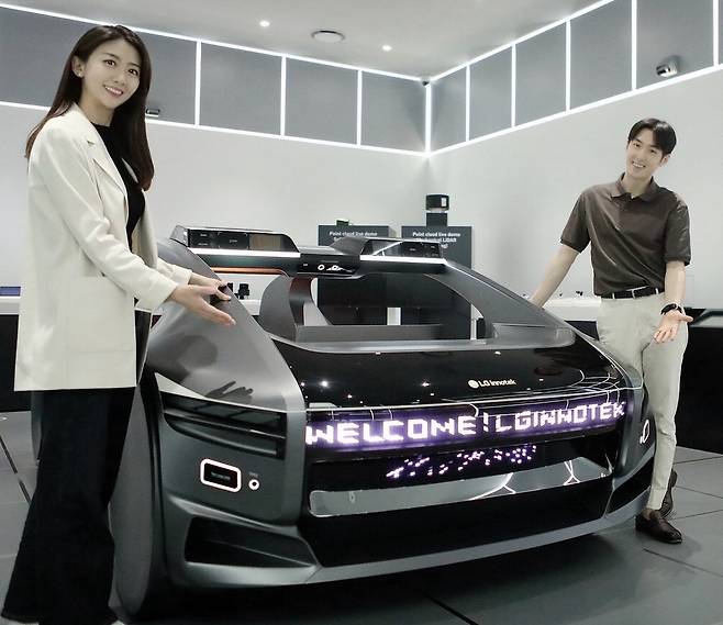LG이노텍 직원들이 미래차 모형에 장착된 차량용 조명 모듈 '넥슬라이드'를 선보이고 있다. 
 LG이노텍