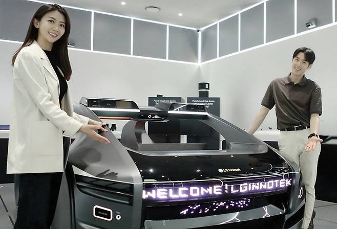 LG이노텍 직원들이 미래차 모형에 장착된 차량 조명 모듈 ‘넥슬라이드’를 선보이고 있다. LG이노텍 제공