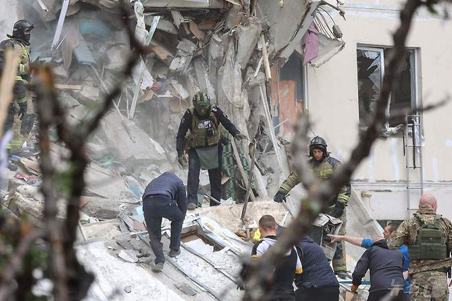 12일(현지시간) 러시아 벨고로드에서 우크라이나 군의 대규모 포격을 받은 아파트가 붕괴된 현장서 소방대원이 수색을 하고 있다. 2024.05.13 ⓒ AFP=뉴스1 ⓒ News1 우동명 기자