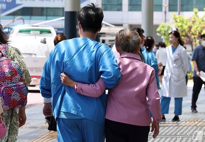 14일 서울 시내의 대형병원에서 한 의료진이 환자를 부축하며 이동하고 있다. 2024.5.14/뉴스1 ⓒ News1 김성진 기자