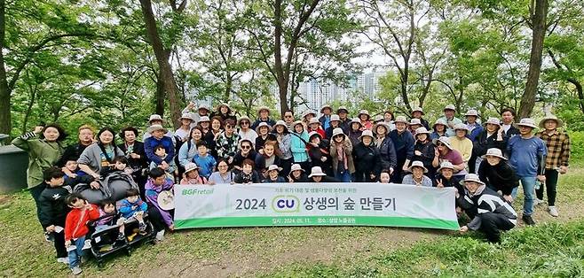지난 11일 서울 상암동 노을공원에서 열린 CU 상생의 숲 만들기 봉사활동 참가자들이 기념촬영을 하고 있다.
