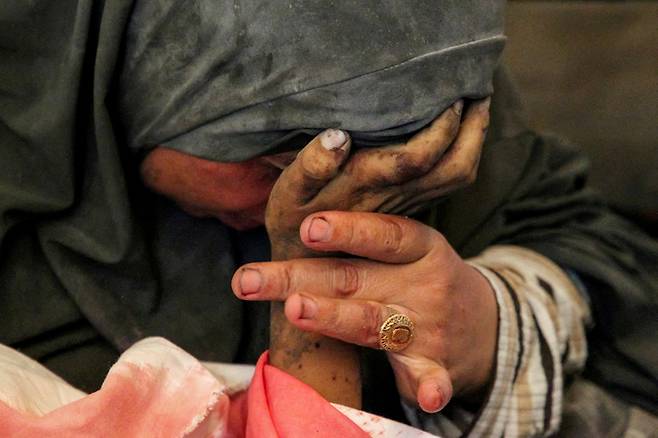 지난 9일(현지시간) 가자지구 최남단 도시 라파에서 팔레스타인 여성이 이스라엘군의 공습으로 사망한 아들의 손을 잡고 울고 있다. 로이터연합뉴스