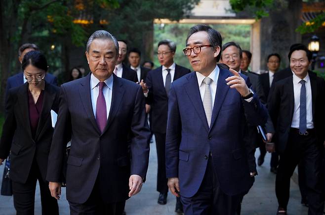South Korean Foreign Minister Cho Tae-yul (right) and his Chinese counterpart Wang Yi stroll at the Diaoyutai State Guesthouse in Beijing following bilateral talks on Monday. (Ministry of Foreign Affairs)