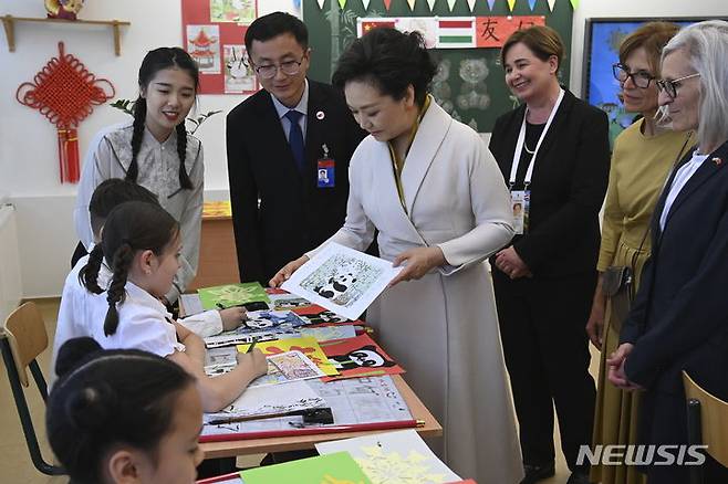 [부다페스트=AP/뉴시스] 시진핑 중국 국가주석의 부인 펑리위안(가운데) 여사가 9일(현지시각) 부다페스트에 있는 중-헝가리 이중언어학교를 방문해 자이안트 판다를 그리는 학생들과 소통하고 있다. 왕이 외교부장은 시진핑 주석의 유럽 순방에 동행한 펑 여사가 '부인 외교'로 중국의 소프트 파워를 높였다고 말했다. 중국이 퍼스트 레이디의 '부인 외교'를 평가한 것은 이례적이다. 2024.05.14.