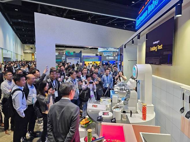 SID 디스플레이 위크 2024에 참가한 삼성디스플레이 부스에서 관람객들이 폴더블 내구성을 테스트하는 로봇쇼를 관람하는 모습ⓒ삼성디스플레이