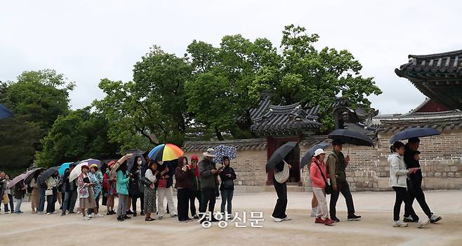부처님오신날인 15일 서울 종로구 창덕궁을 찾은 시민들이 후원관람을 위해 우산을 쓴 채 줄을 서 있다.  정지윤 선임기자