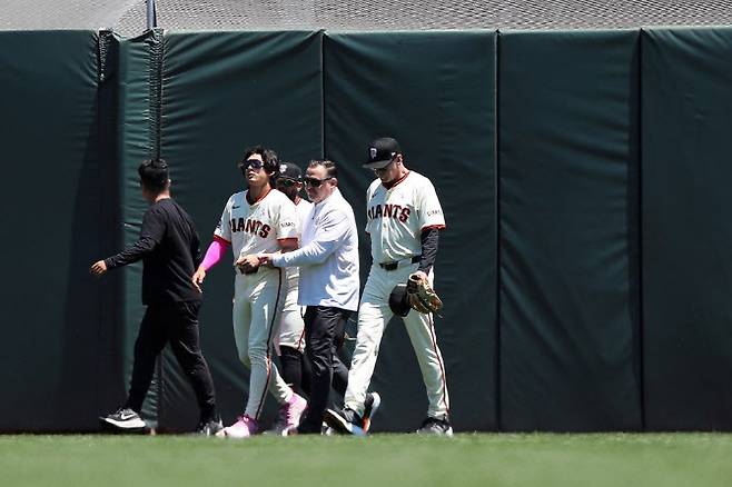 샌프란시스코 자이언츠 이정후가 펜스에 부딪혀 어깨를 다친 뒤 부축을 받으며 경기장을 빠져나오고 있다. 사진=AFPBBNews