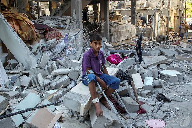 9일(현지시간) 팔레스타인 가자지구 라파에서 한 아이가 이스라엘군의 공습으로 무너진 건물 잔해 위에 앉아있다. 2024.05.09/ ⓒ 로이터=뉴스1 ⓒ News1 박재하 기자