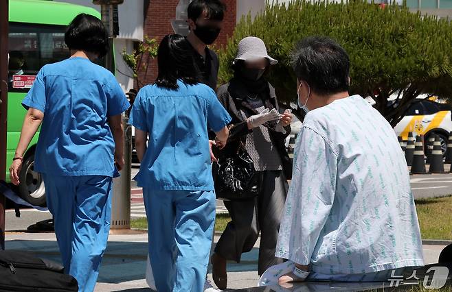 14일 서울 시내의 대형병원에서 한 환자가 휴식을 취하고 있는 가운데, 의료진들이 이동하고 있다. 2024.5.14/뉴스1 ⓒ News1 김성진 기자
