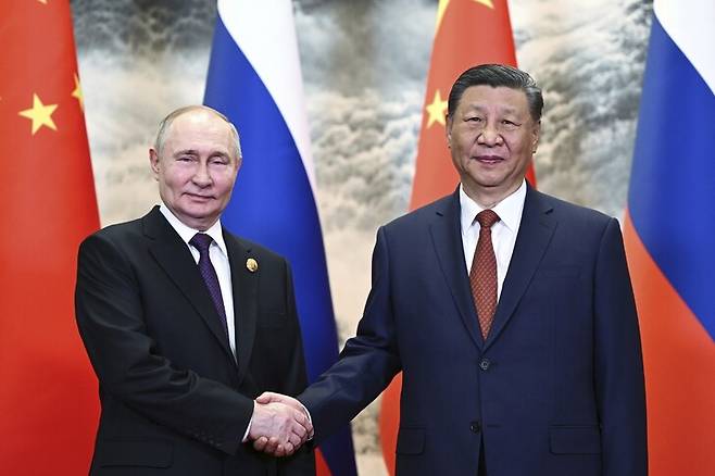 시진핑 중국 국가주석(오른쪽)과 블라디미르 푸틴 러시아 대통령이 16일 중국 베이징에서 만나 악수하고 있다. 베이징/AP 연합뉴스