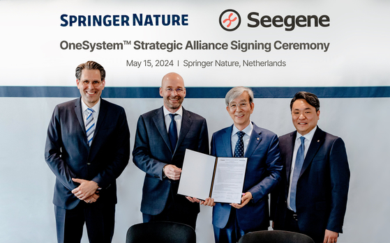 Seegene CEO Chun Jong-yoon, third from left, takes a photo with Frank Vrancken Peeters, second from left, CEO of Springer Nature, after signing an agreement in Houten, Netherlands on May 15. [SEEGENE]