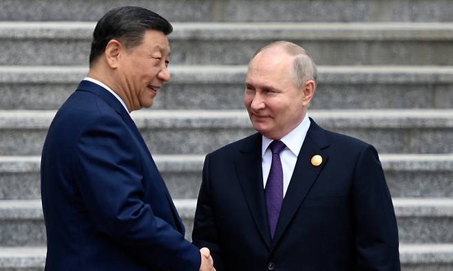 블라디미르 푸틴(오른쪽) 러시아 대통령이 16일 중국 베이징에서 시진핑 중국 국가주석과 만나 악수하고 있다. AP뉴시스