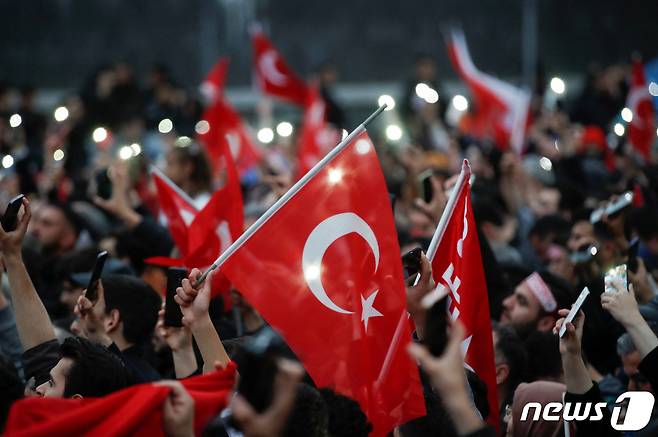 28일(현지시간) 튀르키예 이스탄불에서 레제프 타이이프 에르도안 대통령의 지지자들이 국기를 들어올리고 있다. ⓒ 로이터=뉴스1 ⓒ News1 정윤영 기자