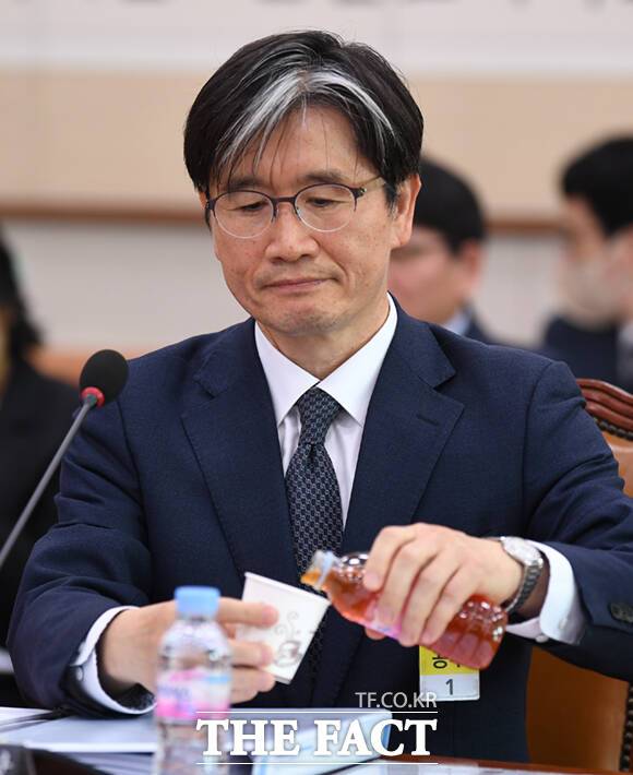 테이블에 놓인 빨간 음료를 따르는 오 후보.