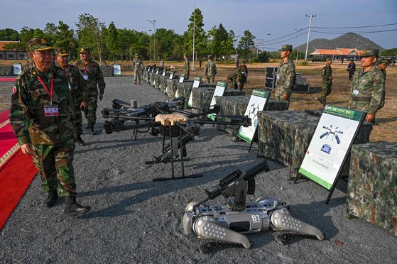 16일(현지시간) 캄보디아 왕립 국군 부사령관 겸 캄보디아 왕립 육군 사령관 마오 소판(왼쪽) 장군이 헌병 기지에서 열린 캄보디아-중국 드래곤 골드-2024 훈련 중 중국군 이 전시한 무기를 살펴보고 있다. AFP=연합뉴스