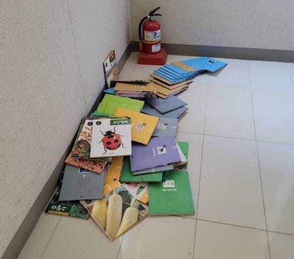 아파트 복도로 추정되는 곳에 버려져 있는 책. 사진=온라인커뮤니티