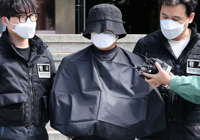 부산 법원 앞에서 생방송하던 유튜버를 살해한 혐의를 받는 50대 유튜버가 16일 부산 연제경찰서에서 검찰 송치를 위해 이동하고 있다. 연합뉴스