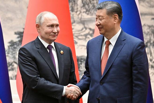 시진핑 중국 국가주석(오른쪽)이 16일(현지시간) 중국을 국빈 방문한 블라디미르 푸틴 러시아 대통령과 베이징에서 만나 악수하고 있다./로이터=뉴스1