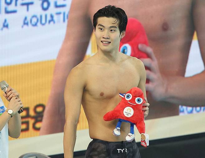 <yonhap photo-3822=""> 파리 올림픽 마스코트 인형 든 황선우 (김천=연합뉴스) 윤관식 기자 = 황선우(강원도청)가 24일 경북 김천실내수영장에서 열린 2024 파리 올림픽 경영 국가대표 선발대회를 겸해 열린 'KB금융 코리아 스위밍 챔피언십' 남자 자유형 100m 결승에서 우승 후 파리 올림픽 마스코트 인형을 들고 웃고 있다. 2024.3.24 psik@yna.co.kr/2024-03-24 17:44:51/ <저작권자 ⓒ 1980-2024 ㈜연합뉴스. 무단 전재 재배포 금지, AI 학습 및 활용 금지></yonhap>