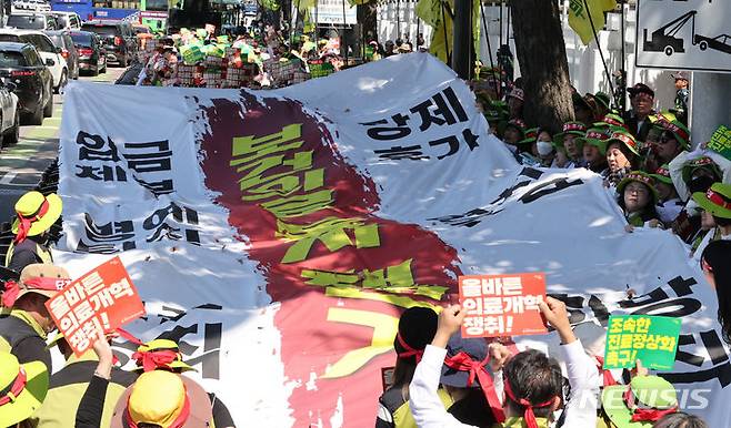 [서울=뉴시스] 김명원 기자 = 지난 14일 서울 종로구 정부서울청사 앞에서 열린 조속한 진료정상화, 올바른 의료개혁 촉구 결의대회에서 보건의료노조 조합원들이 플랜카드를 찟는 상징의식을 하고 있는 모습. 2024.05.14. kmx1105@newsis.com
