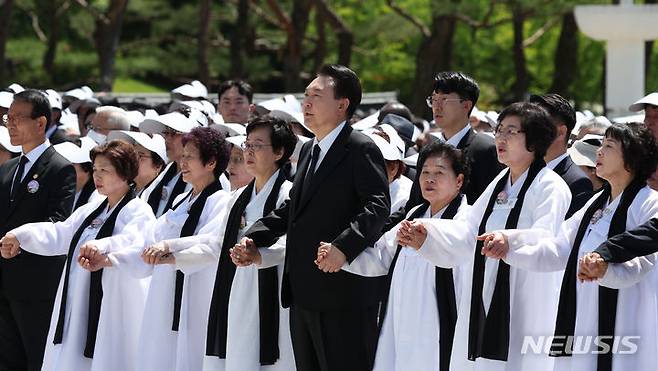 [광주=뉴시스] 조수정 기자 = 윤석열 대통령이 18일 광주 북구 국립5·18민주묘지에서 열린 제44주년 5·18민주화운동 기념식에서 오월어머니회 등 참석자와 손을 잡고 임을 위한 행진곡을 제창하고 있다. 2024.05.18. chocrystal@newsis.com