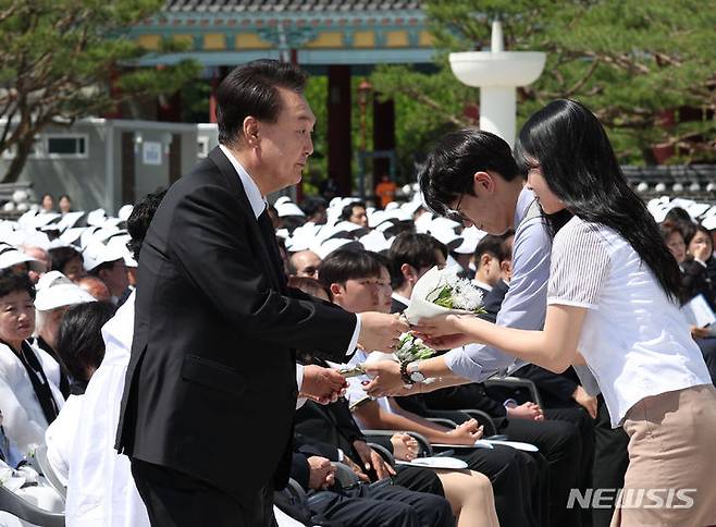 [광주=뉴시스] 조수정 기자 = 윤석열 대통령이 18일 광주 북구 국립5·18민주묘지에서 열린 제44주년 5·18민주화운동 기념식에서 광주지역 고등학생들로부터 5·18민주화운동을 상징하는 이팝나무 꽃을 전달받고 있다. 2024.05.18. chocrystal@newsis.com