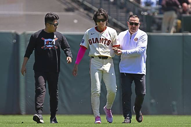 샌프란시스코 이정후가 13일 신시내티전에서 어꺠를 다친 뒤 부축을 받으며 그라운드를 나서고 있다. AP연합뉴스